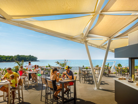 Area pranzo all’aperto con vista mare ad Aminess Planet Camping Maravea Resort, Istria, Croazia.
