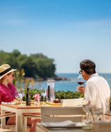 Una pareja disfruta de una comida y vino junto al mar en Aminess Maravea Camping Resort en Istria, Croacia.