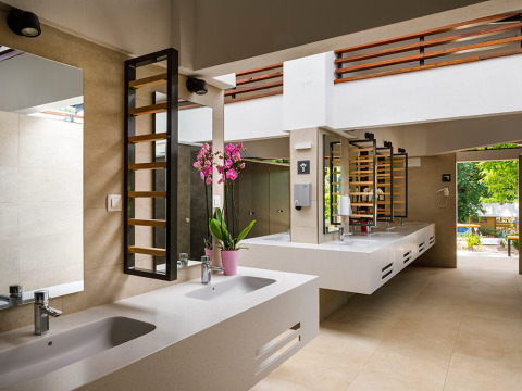 Baño comunitario moderno con varios lavabos y espejos en Aminess Planet Camping Maravea Resort en Istria, Croacia.