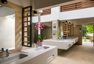 Moderne gezamenlijke badkamer met meerdere wastafels en spiegels bij Aminess Planet Camping Maravea Resort.
