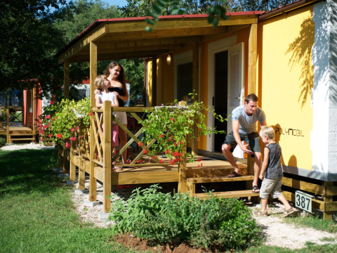 Een gezin geniet op de veranda van Maravea Premium Holiday Home bij Aminess Planet Camping Maravea Resort, Kroatië.