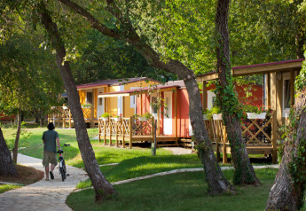 Uomo con bici percorre sentiero tra le case vacanza Maravea Premium immerso nel verde in Croazia.