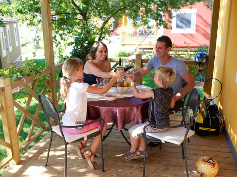 Gezin eet samen op het terras van Maravea Premium Holiday Home bij Aminess Planet Camping Maravea Resort in Kroatië.