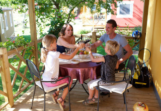 Gezin eet samen op het terras van Maravea Premium Holiday Home bij Aminess Planet Camping Maravea Resort in Kroatië.