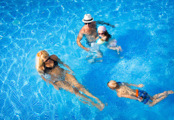 Famiglia che nuota e si rilassa in piscina al Maravea Premium Holiday Home presso Aminess Planet Camping Maravea Resort in Croazia.