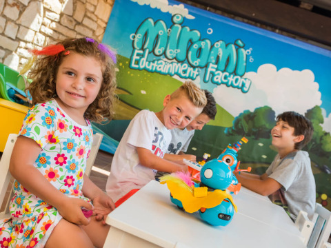 Kinderen spelen en lachen aan een tafel in Miramí Family Village, Aminess Planet Camping Maravea Resort, Kroatië.