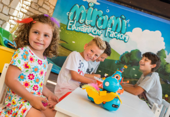 Bambini che giocano e sorridono a un tavolo al Miramí Family Village, Aminess Planet Camping Maravea Resort in Croazia.