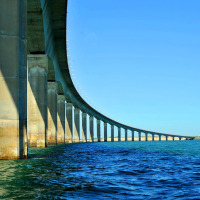 Foto van de brug bij La Flotte in Nouvelle-Aquitaine, Frankrijk, over het water met een zeilboot.