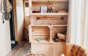 Gemütliche Lodge-Ecke mit Sessel, Teetisch und Holzregal im Smûk Fjildhuske, Smûk Recreatie, Niederlande.