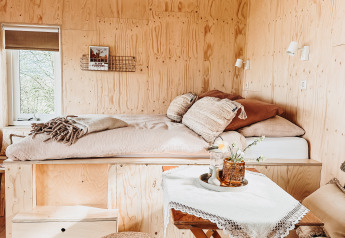 Cozy wooden interior with rustic beams at Smûk Fjildhuske lodge, Smûk Recreatie, Netherlands.
