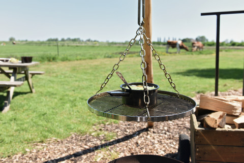 Buitenbarbecue aan Smûk Fjildhuske, Smûk Recreatie in Nederland, met pot en lepel op het rooster.