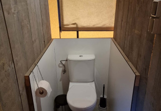 Toilet i en safari-telt på Recreatiepark De Achterste Hoef i Holland, med trævægge og minimal privatliv.