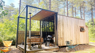Acogedora cabaña pequeña de madera con terraza, parrilla y banco en el bosque de Cosy Cabins, Limburgo, Bélgica.