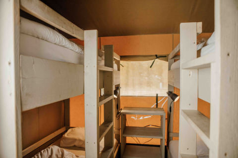 Indvendigt billede af en safaritelt med køjesenge og bord på Veluwepark de Bosgraaf i Holland.