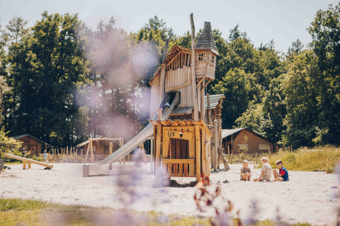 Kinder spielen am Holzspielplatz bei Safarizelten im Veluwepark de Bosgraaf, Niederlande, im Sommer.