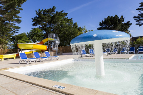 Buitenzwembad met glijbaan en paddenstoelfontein bij Flower Camping Port de la Chaîne in Bretagne, Frankrijk.