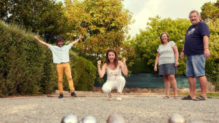 Quatre personnes jouent à la pétanque sur un terrain en gravier au Flower Camping Port de la Chaîne, Bretagne.