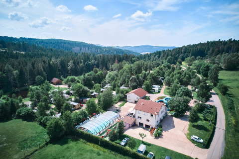 Luftfoto af Flower Camping La Sténiole feriepark omgivet af skov i Grand Est, Frankrig, med swimmingpool.