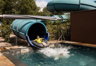 Kinder rutschen auf einer Wasserrutsche im Flower Camping La Sténiole, Ferienpark in Grand Est, Frankreich.