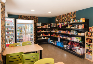 Lille butik med hylder fyldt med snacks og drikkevarer på Flower Camping La Sténiole i Grand Est, Frankrig.