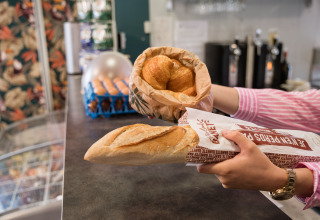Frisches Baguette und Croissants werden an einem Tresen im Flower Camping La Sténiole, Grand Est, Frankreich gereicht.