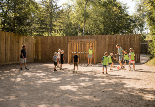 Kinder spielen Fußball im Freien bei schönem Wetter im Flower Camping La Sténiole, Grand Est, Frankreich.