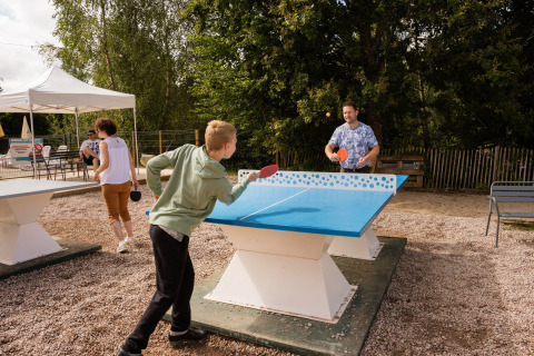 Menschen spielen Tischtennis im Freien im Flower Camping La Sténiole Ferienpark in Grand Est, Frankreich.