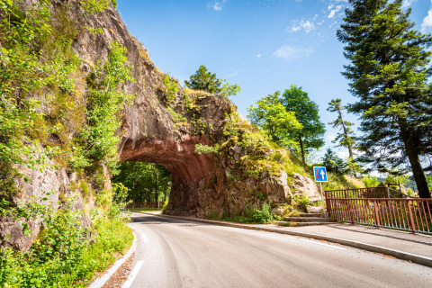 Naturskønt vejstræk i nærheden af Granges-Aumontzey, Grand Est, Frankrig, med vej gennem klippebue.
