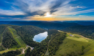 Panoramisk udsigt over bjerge, søer og skove nær Granges-Aumontzey i Grand Est-regionen, Frankrig ved solnedgang.