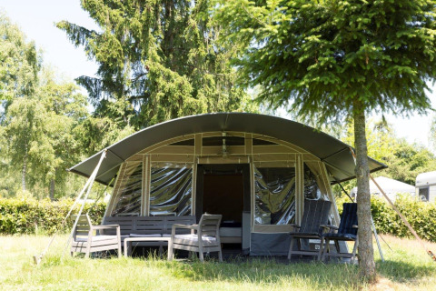 Tenda lodge di lusso ad Auf Kengert, Lussemburgo, con sedute all’aperto tra alberi verdi e natura.