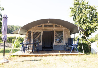 Nommerlayen Lodge at Camping Nommerlayen in Luxembourg, featuring a shaded terrace with outdoor seating.