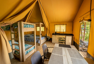 Indvendig udsigt over Tente safari hos Flower Camping La Sténiole i Frankrig med køjesenge og køkken.