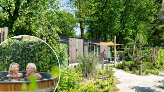 Veluwehoeve Wellness lodge met groene tuin en ouder stel genietend van een warme hottub buiten.