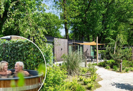 Veluwehoeve Wellness lodge con jardín verde y una pareja mayor relajándose en un jacuzzi al aire libre.