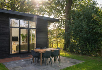 Comedor exterior en la cabaña Wellness Boutique baby de Holiday Park Mölke, rodeado de naturaleza en Países Bajos.