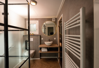 Modernes Badezimmer der Wellness Boutique baby im Holiday Park Mölke in den Niederlanden mit Glasdusche.