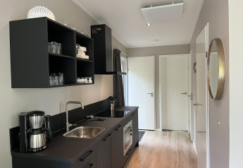 Angolo cottura moderno al Just Nature Light lodge a De Hooge Veluwe, Paesi Bassi, con armadi neri.