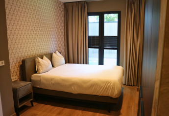 Bedroom in Forest Lodge Deluxe at Holiday Park BreeBronne, Netherlands, featuring modern decor.