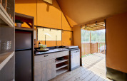 Modern safari tent kitchen at Rangerlodge in Familievakantiepark Krieghuusbelten, Netherlands, with view.