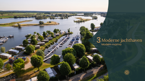 Luchtfoto van een moderne jachthaven met glampingverblijven en boten op een meer in groene omgeving.