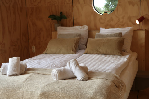 Et komfortabelt soveværelse på Wrap house med sauna og badekar ved Resort de Parel i Holland.