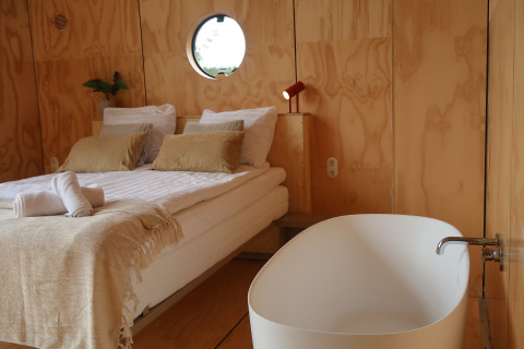 Lodge moderna Wrap house con sauna e vasca da bagno al Resort de Parel, Paesi Bassi. Pannelli in legno, atmosfera accogliente.