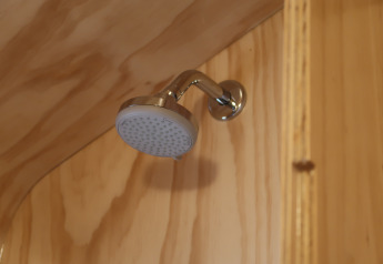 Pommeau de douche dans la salle de bain en bois du Wrap house avec sauna et baignoire, Resort de Parel, Pays-Bas.