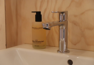 Modern sink with chrome faucet and body wash at Wrap house with sauna in Resort de Parel, the Netherlands.
