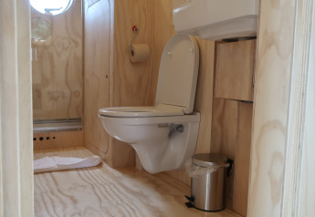 Salle de bains avec WC suspendu, lavabo et poubelle au Wrap house, Resort de Parel, Pays-Bas.
