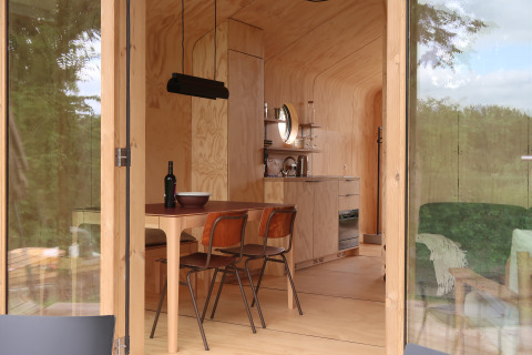 Binnenaanzicht van de Wrap house lodge met modern houten interieur en keuken bij Resort de Parel, Nederland.