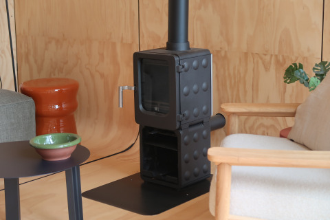 Poêle à bois moderne dans un coin salon cosy de la Wrap house avec sauna et baignoire, Resort de Parel.