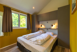 Lyst soveværelse med dobbeltseng i Eco Cottage på De Thijmse Berg, Nederlandene, med moderne design.