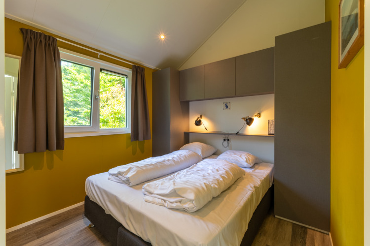 Helles Schlafzimmer mit Doppelbett im Eco Cottage bei De Thijmse Berg, Niederlande, modern eingerichtet.