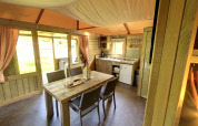 Interno della Kampeerlodge al Familievakantiepark Krieghuusbelten, Paesi Bassi, con cucina e zona pranzo.